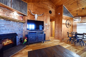 Cozy room with a fireplace, television, and dining area, featuring a unique decorative touch.