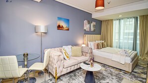 A modern hotel room with a sofa, a dining table, and a bed.