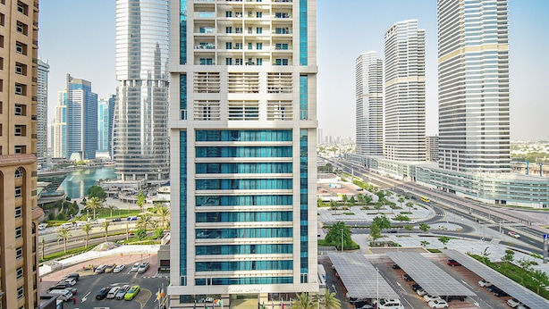 A modern high-rise building with multiple floors, large windows, and a prominent entrance.
