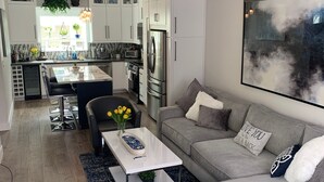 A modern kitchen with white cabinets, a stainless steel refrigerator, and a central island.
