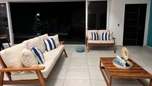 A modern living room with two sofas, a coffee table, and a round ottoman. - Lazo Beach House, Costa del Sol (San Luis, La herradura)