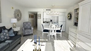 Ein Wohnzimmer mit einer Couch, einem Couchtisch und einem Essbereich mit Tisch und Stühlen.