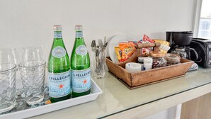 Lasinen tiski, jossa on pulloja San Pellegrino -kuplavettä, laseja, pientä purtavaa ja erilaisia mausteita.