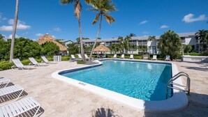 A swimming pool with lounge chairs and palm trees, surrounded by resort buildings. - Overlooking Pool Free Golf Cart Free Kayaks Pickleball (Key Largo)