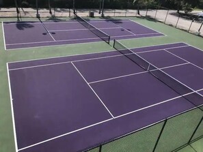 Un court de tennis comprenant plusieurs terrains, chacun délimité par des lignes blanches.