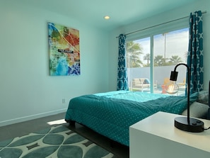A bedroom with a bed, a desk, a lamp, a window with curtains, and a wall map. - Luxurious Villa, Renovated, Fully Featured Mid-Century Modern Meiselman Oasis (Palm Springs)