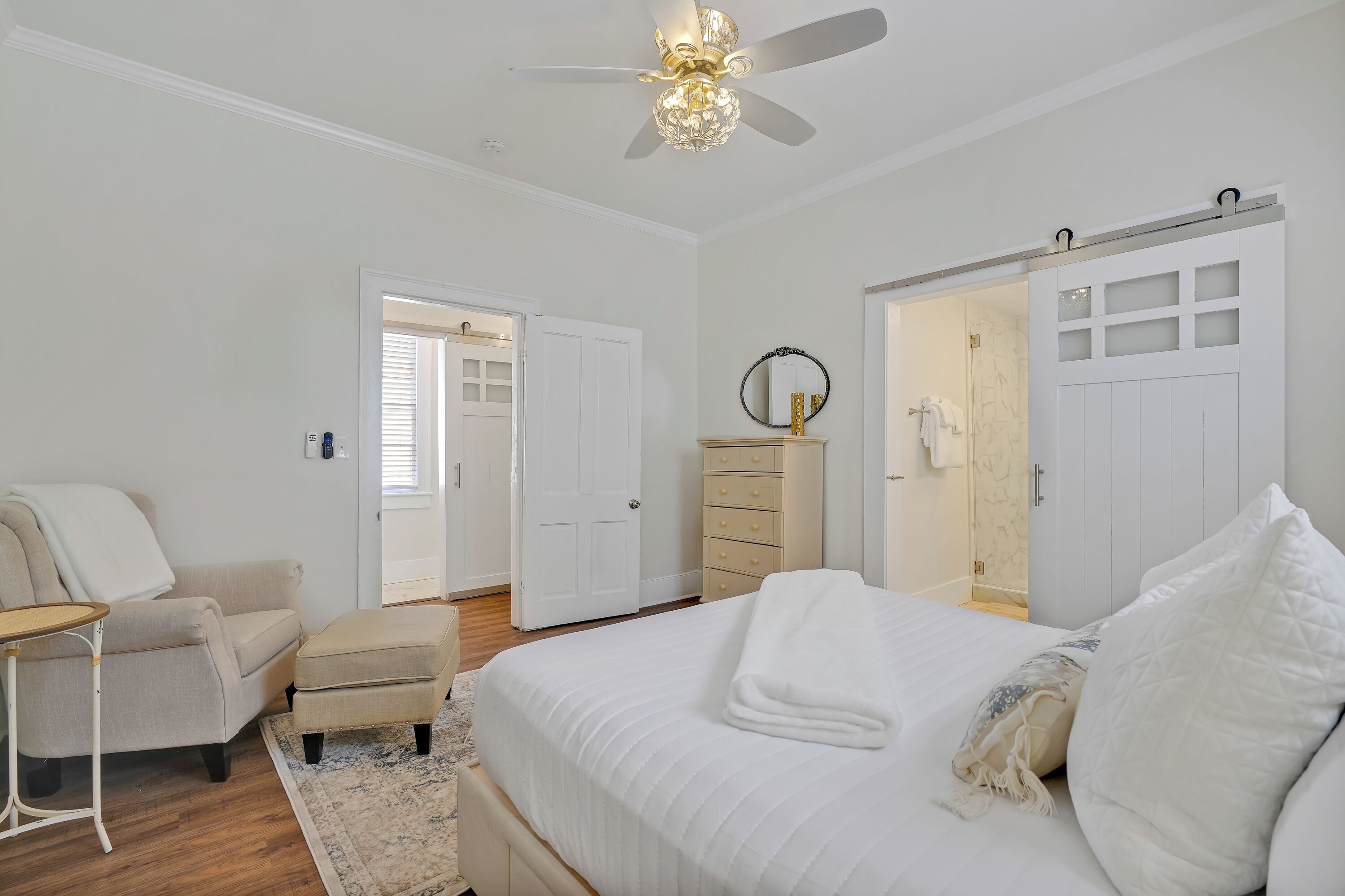 Quarto com cama, poltrona, cômoda e guarda-roupa.