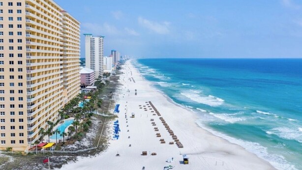 Un hotel frente a la playa con una extensa playa de arena y vista al océano.