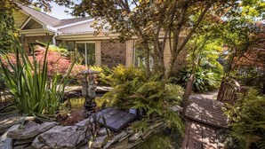 A garden with a stone wall, a statue, and a wooden bench. - The Relaxing Zen Garden. You've found it. (Wilmington)