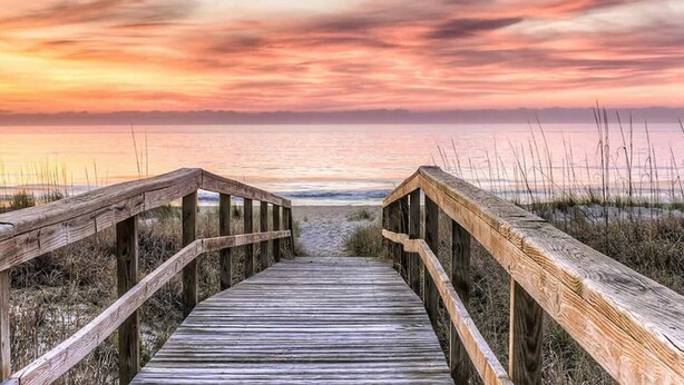 A wooden boardwalk leading to the beach with a sunset in the background. - The Relaxing Zen Garden. You've found it. (Wilmington)