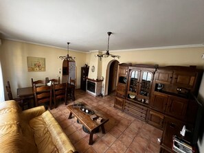 Ein Wohnzimmer mit Kamin, Holzmöbeln und einem Essbereich.