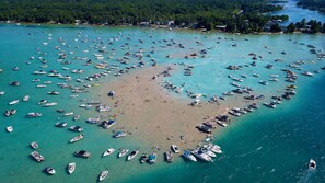 An aerial view of a beach with numerous boats docked and people scattered across the sand.