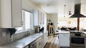 Una cocina moderna con armarios blancos, un lavamanos de acero inoxidable y un horno Bosch.