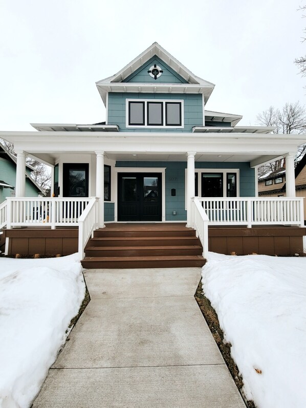 A two-story house with a front porch, a black front door, and a number "607" on the wall. - Luxury on Main, remodeled, homey, fresh and bright! (Bozeman)