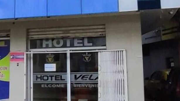 A modern hotel building with a reflective glass facade and a prominent 'HOTEL' sign at the entrance. - Galo Vela (Santo Domingo de los Colorados)
