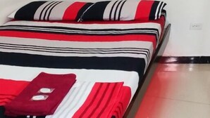 A bedroom with a bed, pillows, and a nightstand. - Galo Vela (Santo Domingo de los Colorados)