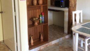 A kitchen with wooden cabinets, a microwave, and a dining table with chairs.