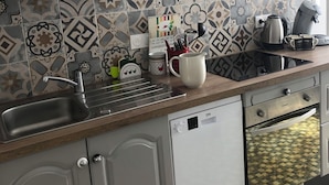 Una cocina con salpicadero de azulejos, electrodomésticos de acero inoxidable y lavavajillas.