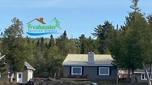 Een huis aan een meer, met een logo voor Freshwater Vacation Rentals.
