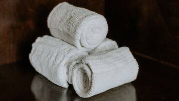 A stack of white towels on a reflective surface.