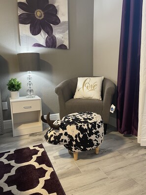 A living room with a sofa, a decorative pillow, a small table with a plant, and a patterned rug. - ☀️WOW☀️ UPDATED with HEATED POOL & HOT TUB HOME 5 MIN TO BEACH 3BD 2BA 2 KING BEDS (Seminole)