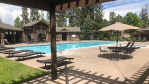 A poolside area with lounge chairs, a table, and umbrellas. - Paradise in The Parks on Westside with summer pool, bike trails and restaurants. (Bend)