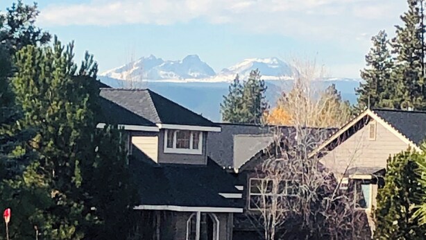 A residential area with houses, a stone pathway, and a mountain range in the background. - Paradise in The Parks on Westside with summer pool, bike trails and restaurants. (Bend)