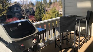 A barbecue grill on a balcony with a view of houses and trees. - Paradise in The Parks on Westside with summer pool, bike trails and restaurants. (Bend)