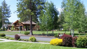 A residential area with a large wooden house, well-maintained lawns, and various shrubs. - Paradise in The Parks on Westside with summer pool, bike trails and restaurants. (Bend)