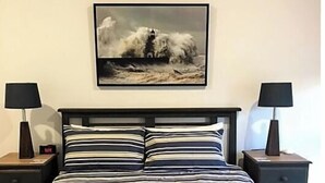 A bedroom with a bed, two bedside tables, and a framed picture on the wall. - Hampton Cottage - " A Place To Call Home" (Port Albert)