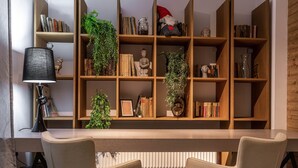 Una sala moderna con una estantería de madera, un escritorio y dos sillas.