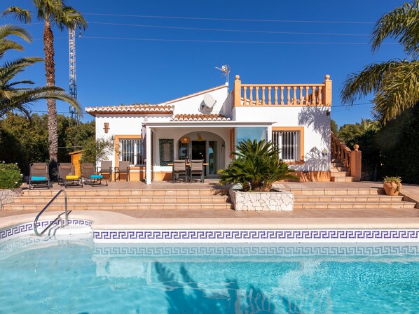 Una casa de dos pisos con piscina delantera.