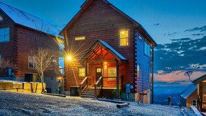 A wooden cabin with a porch, a staircase, and a view of the mountains. - Near Dollywood! Beautiful Mountain Views, Hot Tub & Resort Indoor Heated Pool (Sevierville)