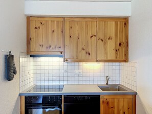 A kitchen with wooden cabinets, a dishwasher, and a stove.