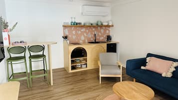 A compact living space with a kitchenette, a dining area, and a seating area.