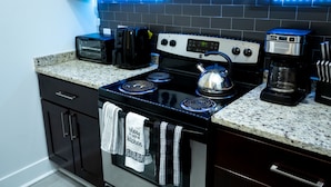 A kitchen with a stove, microwave, toaster, and coffee maker. - 💎 Sanitized*LUXURY* Relaxing*MODERN APT In the HEART OF DOWNTOWN (Baltimore)
