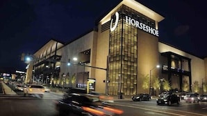 A horseshoe-shaped building with a large sign reading "HORSESHOE" at night. - 💎 Sanitized*LUXURY* Relaxing*MODERN APT In the HEART OF DOWNTOWN (Baltimore)