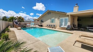 A backyard with a swimming pool, a slide, and outdoor seating. - Desert Pool Retreat (Mesquite)