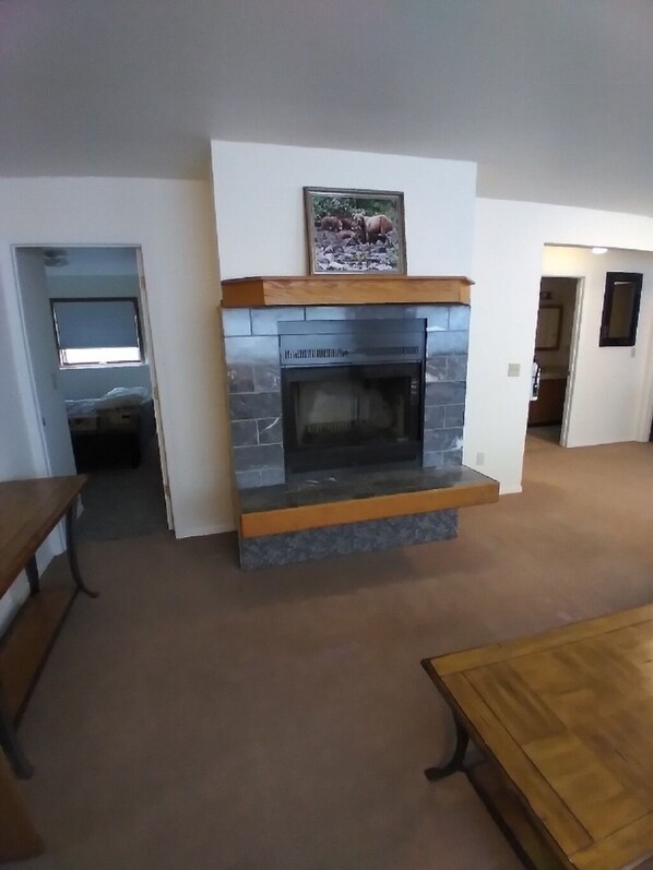 Una sala de estar con chimenea de piedra, una mesa de madera y un banco.