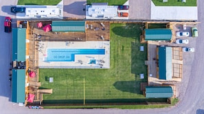 An aerial view of a campground with a swimming pool, RV parking, and outdoor seating areas. - Do Drop Inn RV Resort and Cabins (Cartwright)