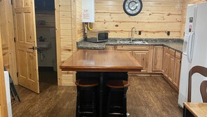A wooden-paneled kitchen with a central island, a sink, and a refrigerator. - Do Drop Inn RV Resort and Cabins (Cartwright)