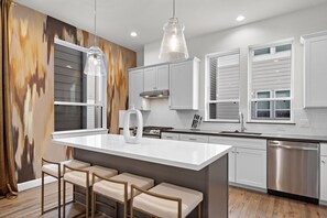 Enjoy cooking and socializing in this kitchen with a central island and bar stools.