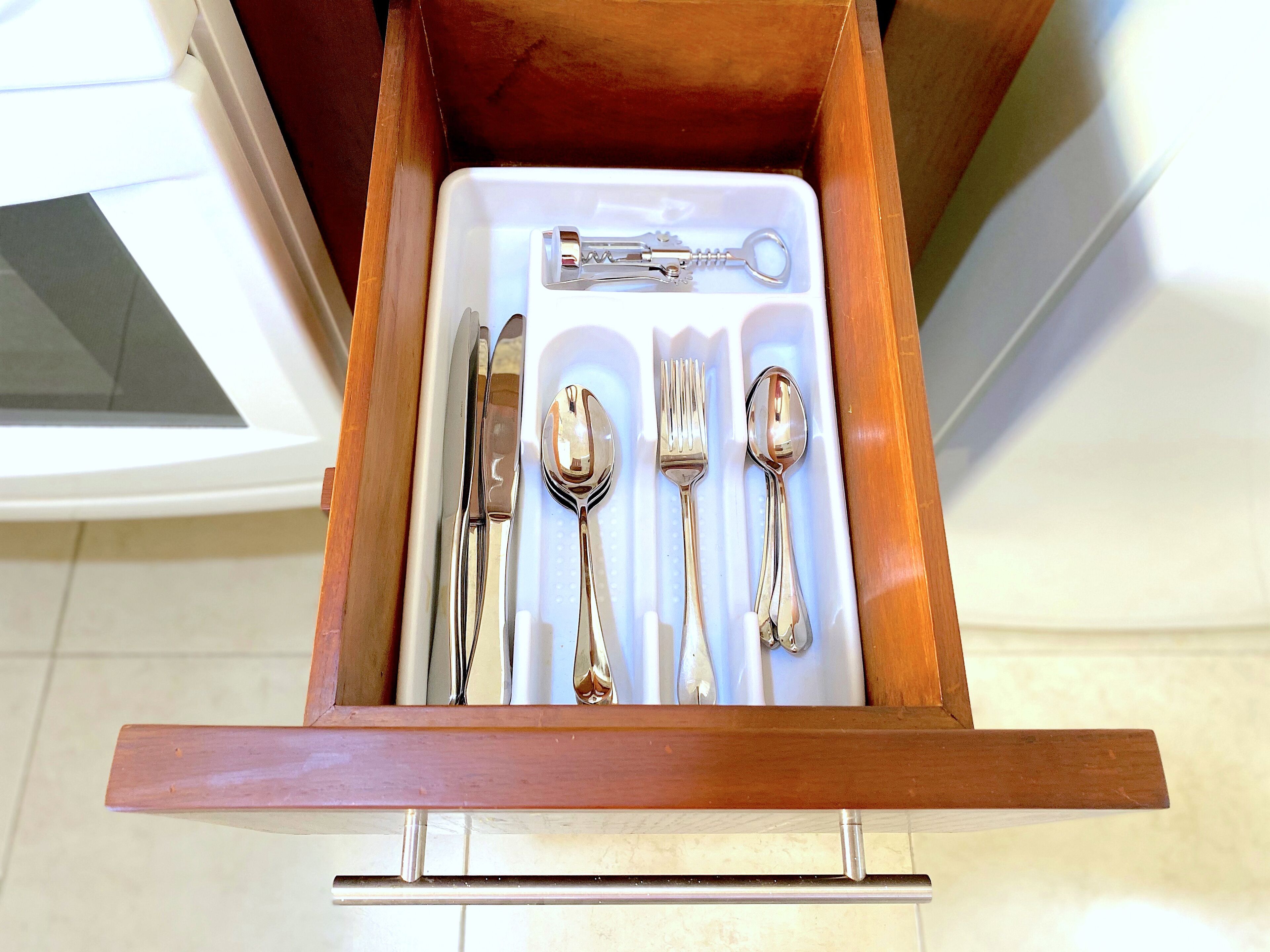 A drawer containing a set of silverware including a fork, knife, and spoon.