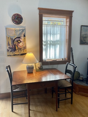 A dining table with chairs, a lamp, a decorative bowl, and a framed picture on the wall.