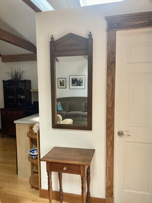 A room with a wooden table, a mirror, and a door.