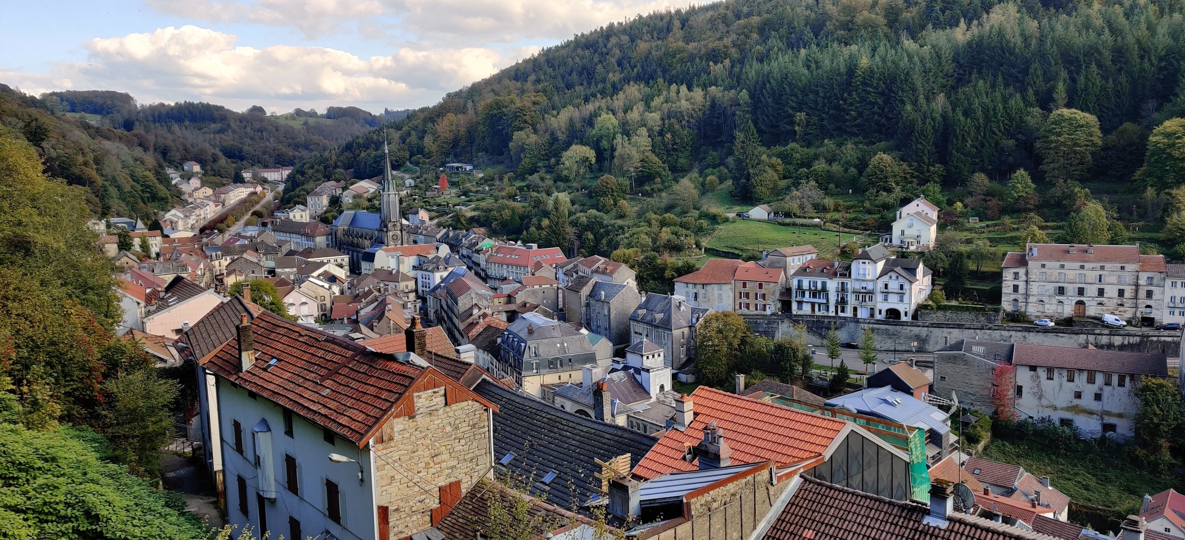 A town with historic buildings, a church, and a hillside backdrop.