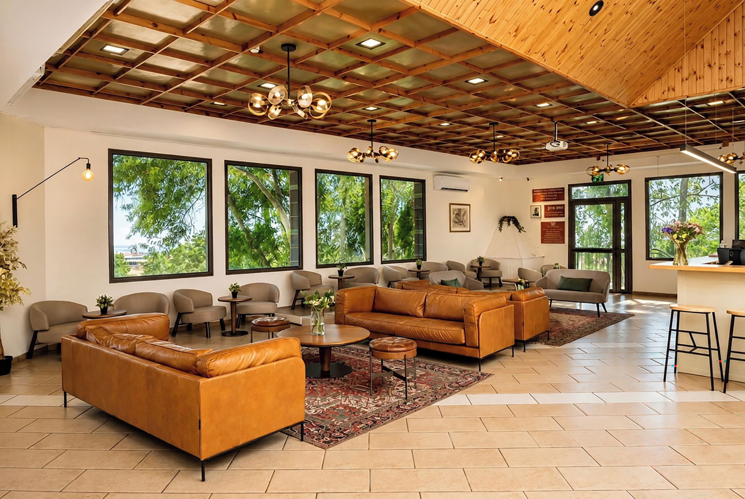 A spacious living area with leather sofas, a coffee table, and a large window overlooking greenery.