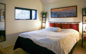 A bedroom with a large bed, a window, a cityscape painting, and a plant on a shelf. - Nice home in Skjern with kitchen (Skjern)