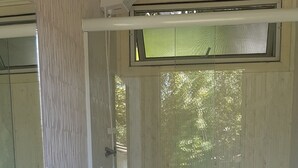 Een kleine badkamer met een wit wastafelmeubel, toilet en douche.