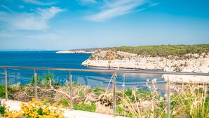 A coastal view with a rocky cliff and a clear blue sea. - Plaça de sa Punta, 4, 07750 Cala Galdana, Balearic Islands, Spanyolország (Cala Galdana)